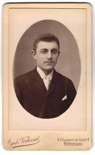 Fotografie Egide Verhassel, Bruxelles, Chaussee de Gand 4, Junger Mann im schwarzen Anzug mit Krawatte und Anstecktuch