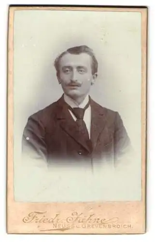 Fotografie Friedr. Jähne, Neuss, Crefelderstr., Eleganter junger Mann im schwarzen Anzug mit Krawatte und Seitenscheitel