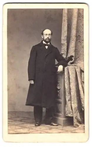 Fotografie A. Schnackenburg, Görlitz, Herr im dunklen Mantel mit Brille und Vollbart