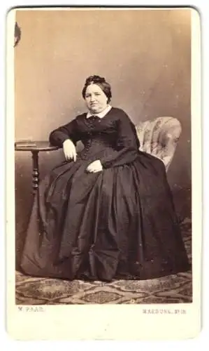Fotografie M. Paar, Marburg / Lahn, Dame im dunklen weiten Kleid mit Schleife im Haar