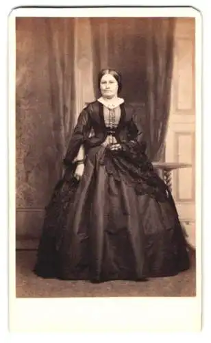 Fotografie Hennah & Kent, Brighton, englische Dame im weiten dunklen Kleid mit Überrock und geflochtenen Haaren