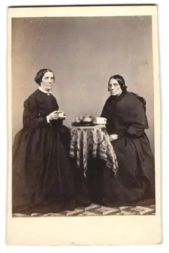 Fotografie F. Chabert, Marburg, zwei ältere Damen beim Kaffeekranz in dunklen Kleidern, Wangen getönt