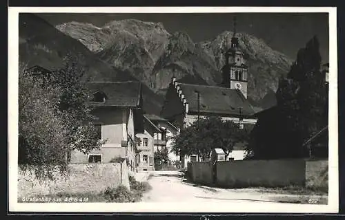 AK Absam, Strassenpartie mit Kirche vor Bergen