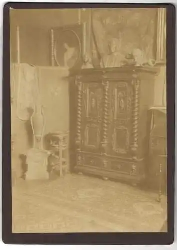 Fotografie Inneneinrichtung, orpulenter Wandschrank mit Verzierungen, Büsten & Amphore