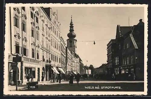 AK Wels, Stadtplatz mit Passanten und Kirchturm