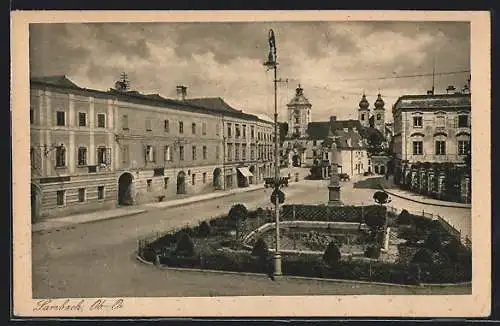 AK Lambach /Ob.-Oe., Strassenpartie mit Gebäudeansicht und Denkmal
