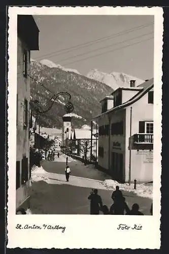 AK St. Anton a. Arlberg, Strassenpartie mit Gasthaus und Kirche im Schnee