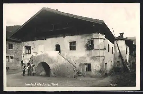 AK Landeck-Perfuchs / Tirol, Passanten vor einem alten Steinhaus