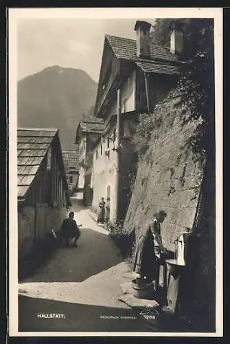 AK Hallstatt, Brunnen in einer Gasse im Ort