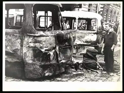 Fotografie unbekannter Fotograf, Ansicht Prag / Praha, Prager Frühling 1968, Demonstrant vor ausgebrannter Strassenbahn