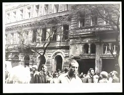Fotografie unbekannter Fotograf, Ansicht Prag / Praha, Prager Frühling 1968, Demonstrantenzug vor zerschossener Fassade