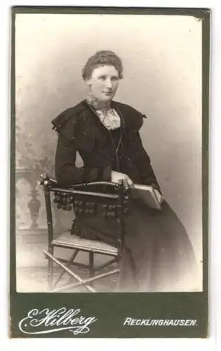 Fotografie Ernst Hilberg, Recklinghausen, Grosse Geldstr. 10, Junge Dame im Kleid mit einem Buch