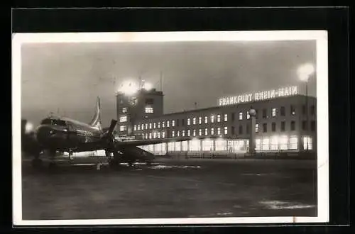 AK Frankfurt a/M, Flughafen Rhein-Main, Propellerflugzeug und Gebäude bei Nacht