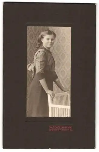 Fotografie W. Schölermann, Heide i. H., junge Frau im Kleid mit geflochtenem Zopf und Haarschleife