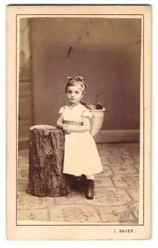 Fotografie L. Bauer, Wien, niedliches Mädchen im Kleid mit Tragekorb auf dem Rücken