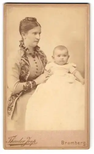 Fotografie Theodor Joop, Bromberg, junge Mutter im verzierten Kleid mit ihrem Kind auf dem Schoss, Flughafen