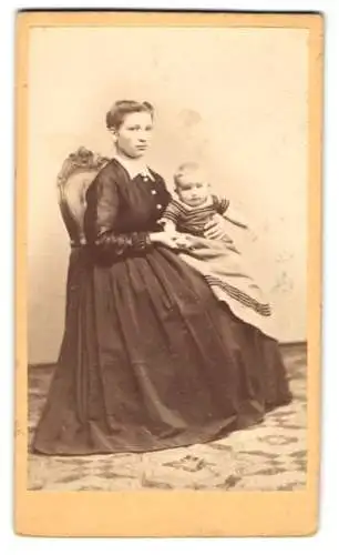 Fotografie Robert Wallich, Berlin, junge Mutter im dunklen Kleid mit ihrem Kind auf dem Schoss, Mutterglück