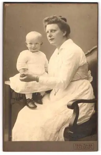 Fotografie Carl Thies, Hannover, Mutter im weissen Kleid mit ihrer Tochter auf dem Tisch, Mutterglück