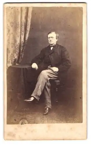 Fotografie C. Combes, Brighton, englischer Herr im Anzug mit Fliege sitzend im Atelier