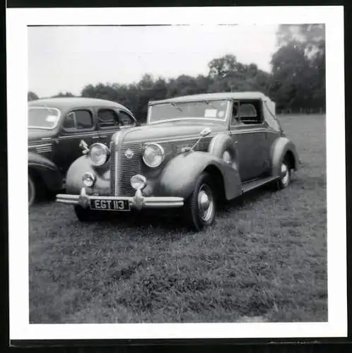 Fotografie Auto Cabrio, Cabriolet auf einer Wiese abgestellt