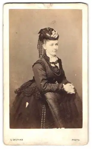 Fotografie Silas Eastham, Manchester, hübsche junge Frau im dunklen Kleid mit Perlenkette und Hut