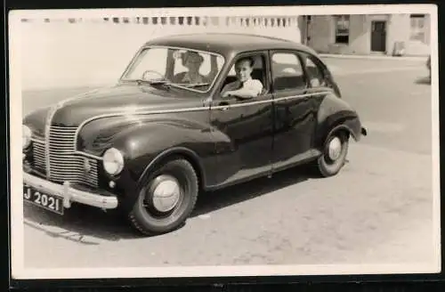 Fotografie Auto, junges Paar in schwarzer Limousine sitzend