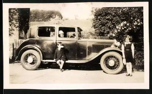 Fotografie Auto, Knabe auf Trittbrett der Limousine sitzend