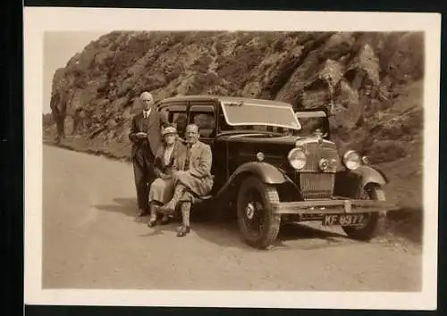 Fotografie Auto, Gentleman & Lady auf Trittbrett der Limousine sitzend