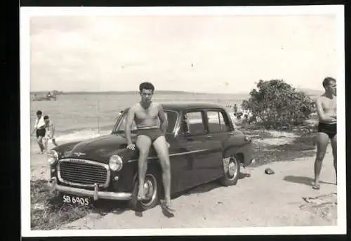 Fotografie Auto, Bursche in Badehose auf PKW-Kotflügel sitzend