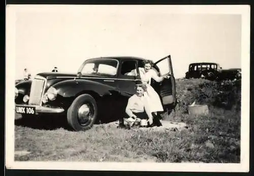 Fotografie Auto, junge Frauen nebst schwarzer Luxus-Limousine