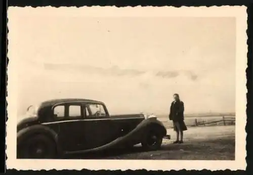 Fotografie Auto, Dame vor Limousine am Strand stehend