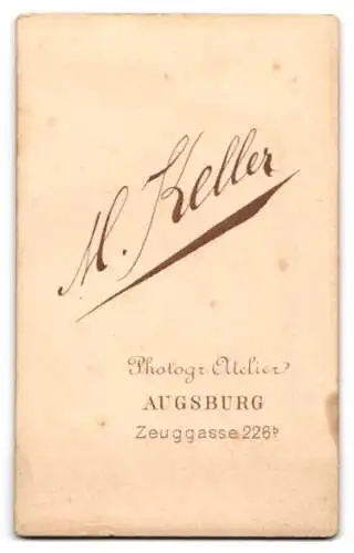 Fotografie M. Keller, Augsburg, Zeuggasse 226b, Junge Dame mit zurückgestecktem Haar und stoischem Blick an einem Tisch