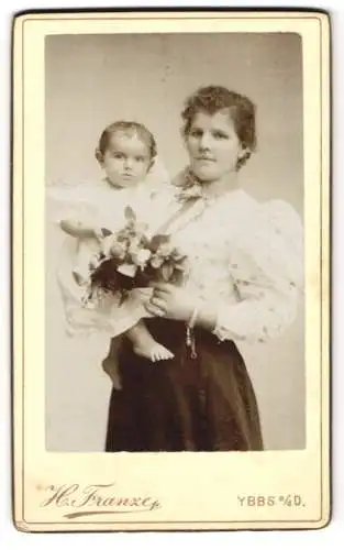 Fotografie H. Franze, Ybbs a. d. D., Bürgerliche Dame mit ihrem kleinen Kind auf dem Arm und einem Strauss Blumen