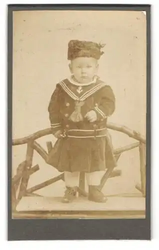 Fotografie Friedrich Weber, Halle a. S., Ludwig Wuchererstr. 44, Kleines Kind im Matrosenkostüm auf einem Stuhl