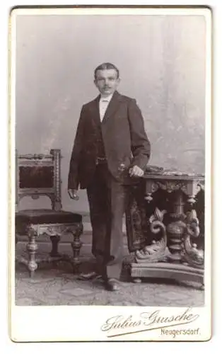 Fotografie Julius Grusche, Neugersdorf i. S., Bürgerlicher Knabe mit Mittelscheitel und leichtem Schnäuzer, im Anzug