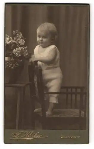 Fotografie J. Kleiber, Stuttgart-Cannstatt, Königstr. 69, Kleinkind im weissen Gewand auf einem Stuhl stehend