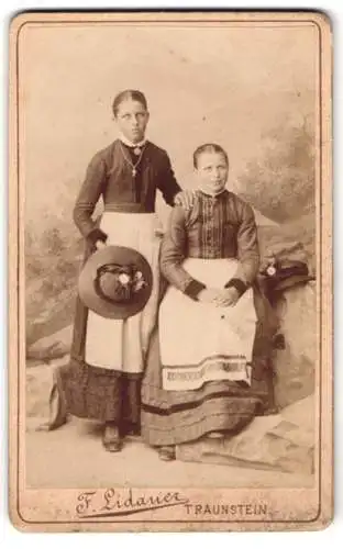 Fotografie F. Lidauer, Traunstein, Königstrasse, Zwei junge Frauen in Tracht, eine mit Hut und einer Kreuzkette