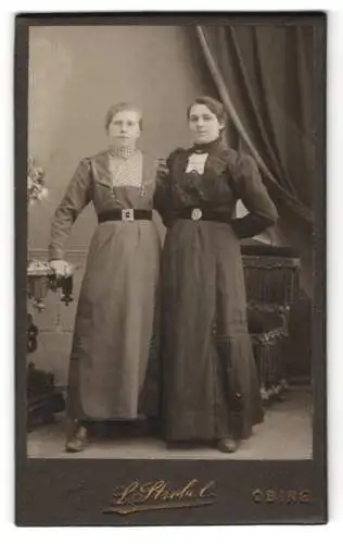 Fotografie L. Strobel, Obing, Zwei junge Frauen Arm in Arm in Kleidern mit Hüftgürteln