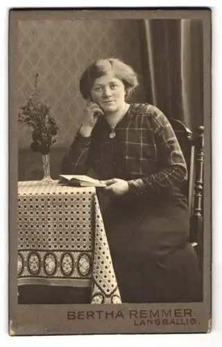Fotografie Bertha Remmer, Langballig, Bürgerliche Dame mit einem Buch am Tisch, ein Medaillon um den Hals