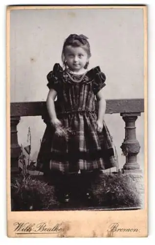 Fotografie Wilh. Beulke, Bremen, Junges Mädchen im karierten Kleid mit einer Schleife im Haar und einer Perlenkette