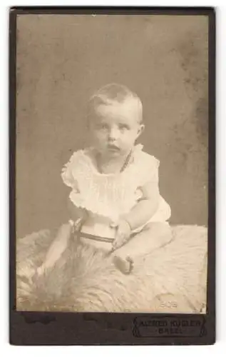 Fotografie Alfred Kugler, Basel, Kleines Kind im weissen Gewand mit grossen Augen und einem Ball in den Händen