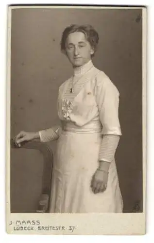 Fotografie J. Maass, Lübeck, Breitestr. 37, Bürgerliche Frau im weissen Kleid mit Taillengürtel und gestreifter Bluse