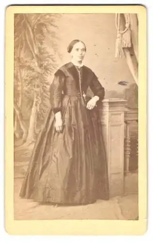 Fotografie L. Greiner, Bernburg, Breite-Str. 104, junge Frau im dunkken Kleid posiert vor einer Studiokulisse