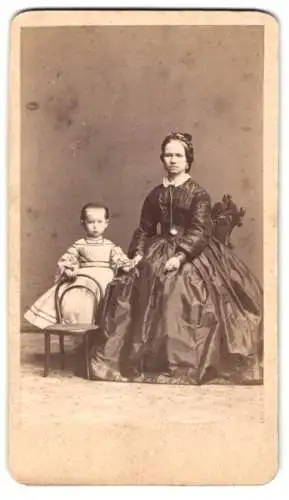 Fotografie Langer & Pommerrenig, Prag, Mutter im dunklen Kleid mit ihrer kleinen Tochter im hellen Kleid
