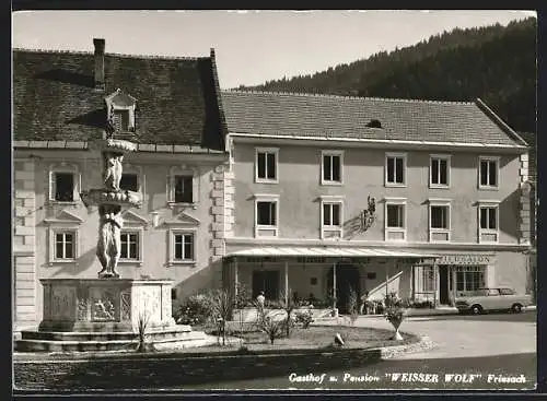 AK Friesach, Gasthof u. Pension Weisser Wolf mit Strassenpartie und Brunnen