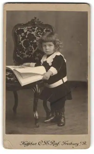Fotografie C. Th. Ruf, Freiburg i. B., Kleines Kind im Samtanzug mit Zeitung