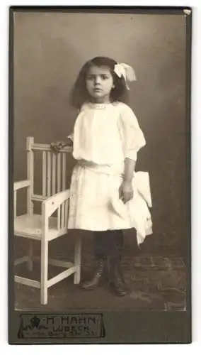 Fotografie H. Hahn, Lübeck, Gr. Burg-Str. 33, Junges Mädchen im weissen Kleid mit Schleife im dunklen Haar