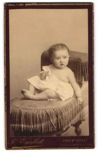 Fotografie J. Wagenblatt, Zweibrücken, Ein Kleinkind im weissen Gewand mit erstauntem Gesichtsausdruck