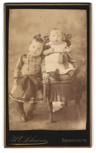 Fotografie J. A. Lehmann, Frankfurt a. M., Kleines Mädchen im Kleid mit grosser Schleife neben ihrer kleinen Schwester