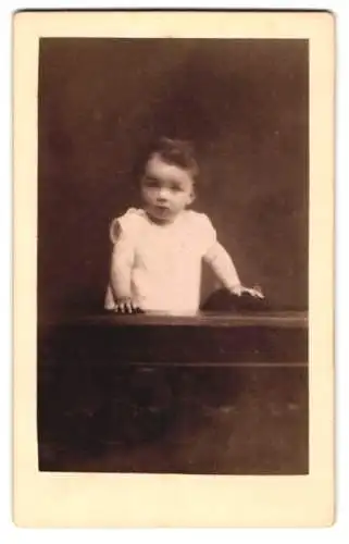 Fotografie Jos. Wörsching, Starnberg, Kleines Kind im weissen Gewand, mit aufmerksamem Blick auf einem Stuhl